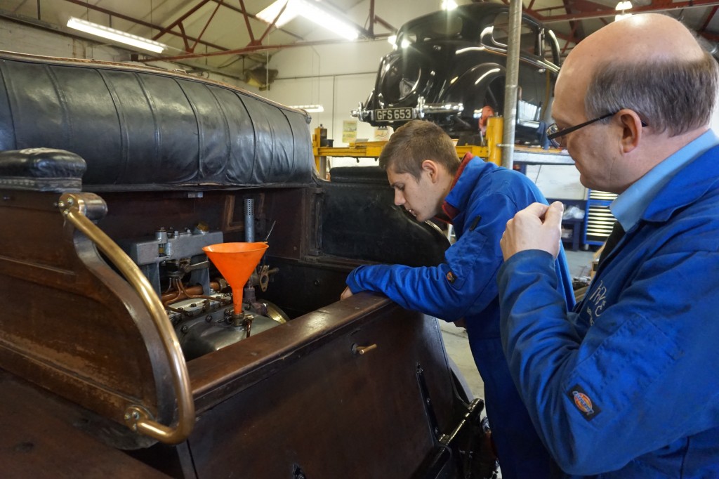 Ian explains the intricacies of servicing this car to our French work experience student